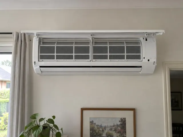 Clean split system indoor unit with open front panel and visible filters on a living room wall in Edwardstown